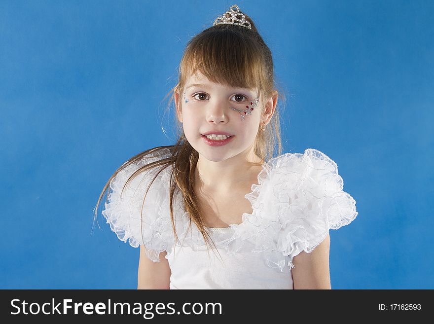 Girl the princess in a white dress opposite to a blue background. Girl the princess in a white dress opposite to a blue background