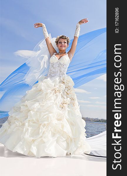 Happy bride on the yacht,  the blue sky