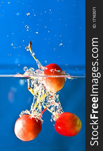 Cherry splashing in blue background