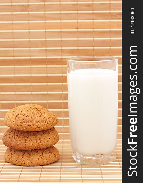 Oatmeal cookies and milk in a glass substrate at a straw
