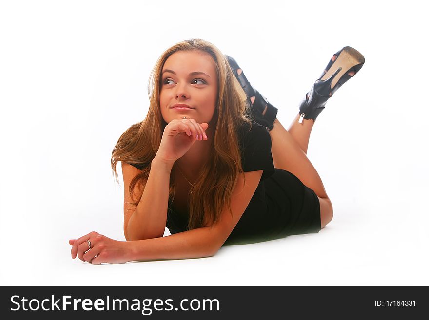 Blonde girl in a black dress lays on a white background and looking aside
