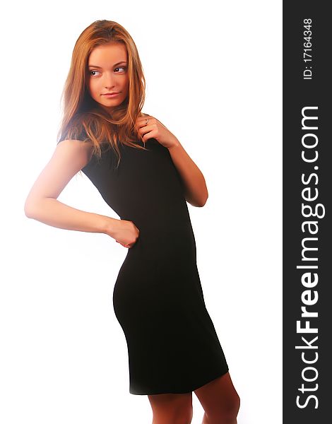 Blonde girl in a black dress stay before a white background and looking aside