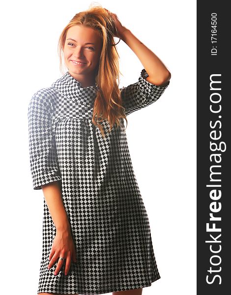 The blonde in a checkered dress on a white background with the dismissed hair looks aside and laughs