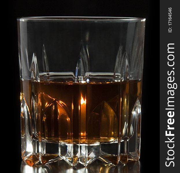 Glass of whiskey or brandy on a black background