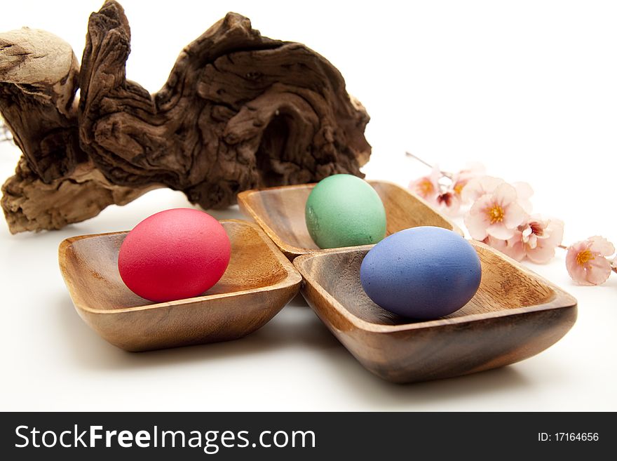 Colored eggs in the wood bowl with flower. Colored eggs in the wood bowl with flower