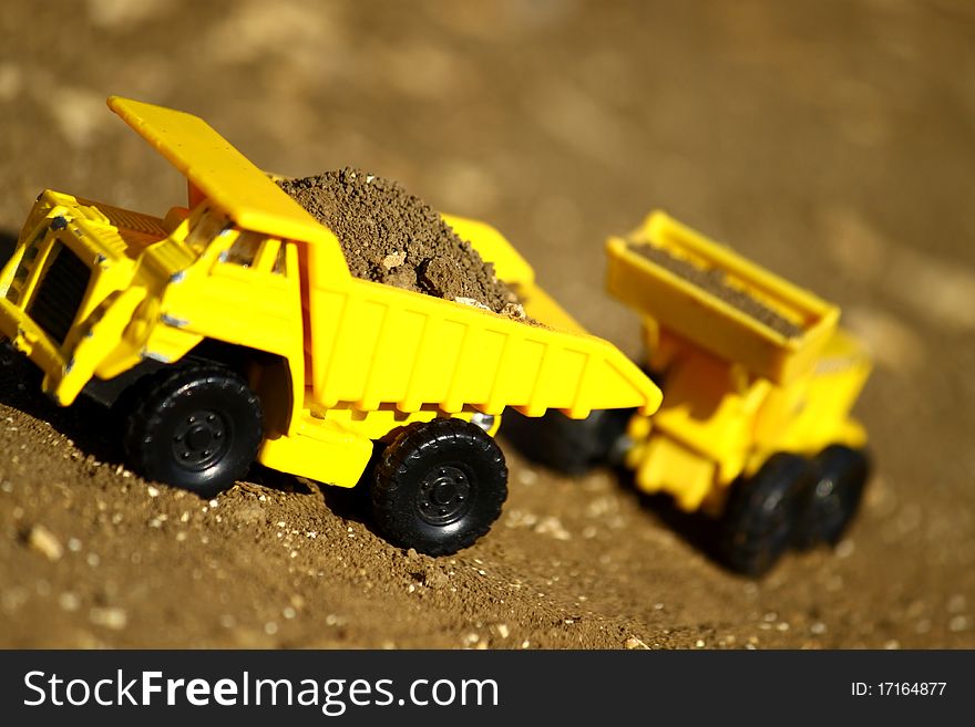 Tiny, toy truck and tractor working with dirt. Tiny, toy truck and tractor working with dirt.