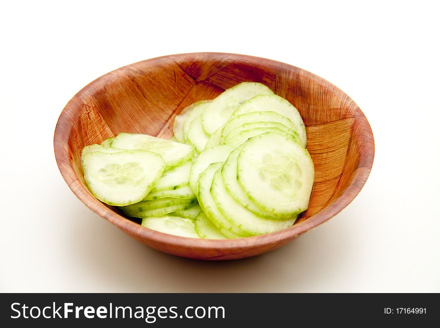 Cut cucumber and in wood bowl