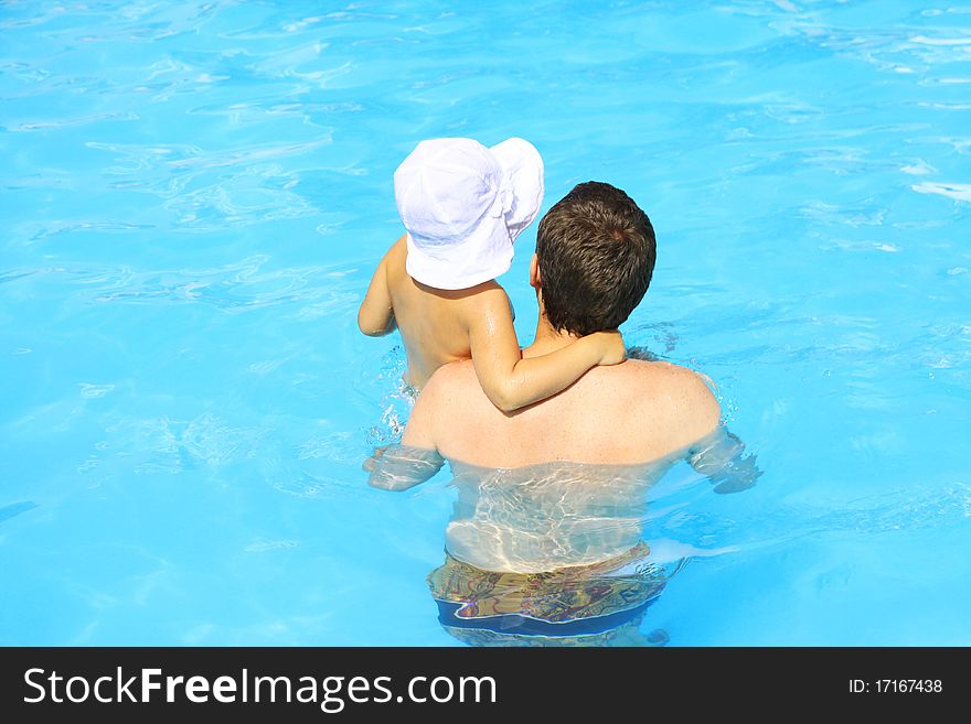Father and daughter swim in the pool