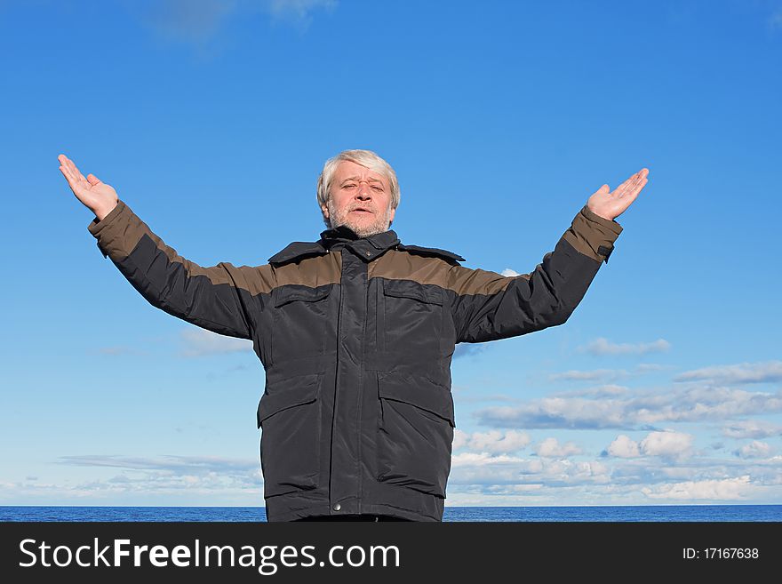 Mature man with grey hair relaxing at the Baltic sea and blue sky on the background. Mature man with grey hair relaxing at the Baltic sea and blue sky on the background.