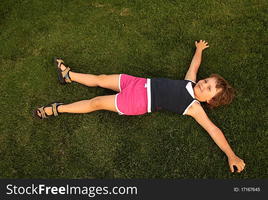 Young girl lie on green grass