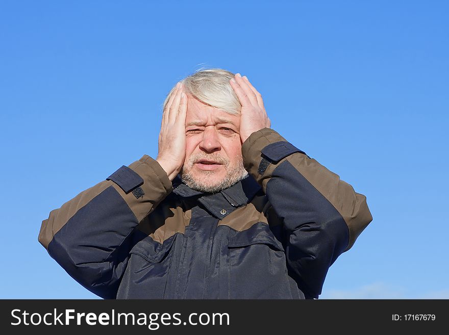 Portrait of mature desperate man with grey hair on blue sky of the background. Portrait of mature desperate man with grey hair on blue sky of the background.