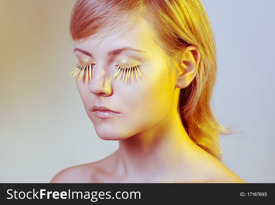 Beautiful young woman wearing yellow petal eyelashes. Beautiful young woman wearing yellow petal eyelashes