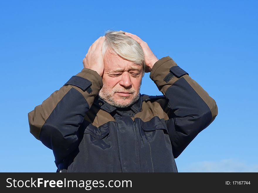 Portrait of mature concerned man with grey hair on blue sky of the background. Portrait of mature concerned man with grey hair on blue sky of the background.