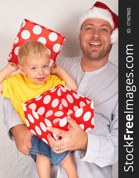 Baby boy with his father for Christmas holding a large gift box