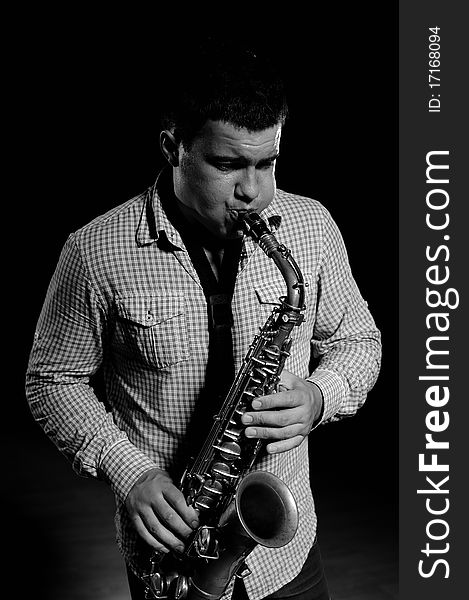 Young handsome man playing music on saxophone