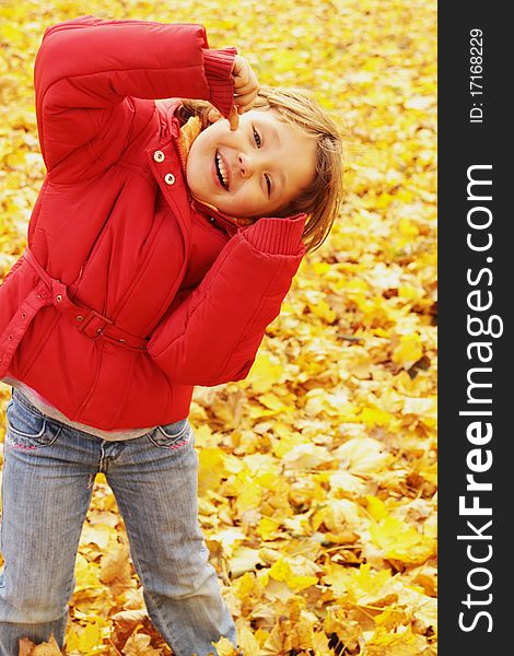 Autumn fun in the park. The girl makes grimaces.