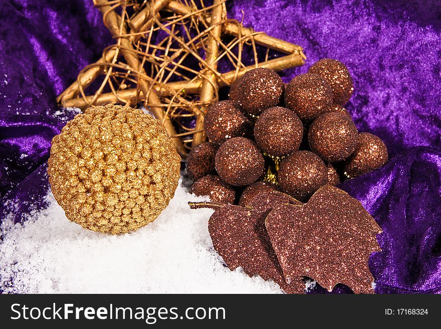 Decorative christmas brown balls with gold star and ball on the snow and on violet background. Decorative christmas brown balls with gold star and ball on the snow and on violet background.