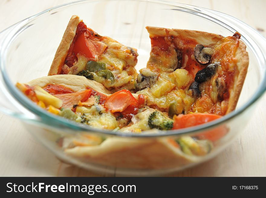 A slice of hot, fresh pizza being served in a bowl. A slice of hot, fresh pizza being served in a bowl.