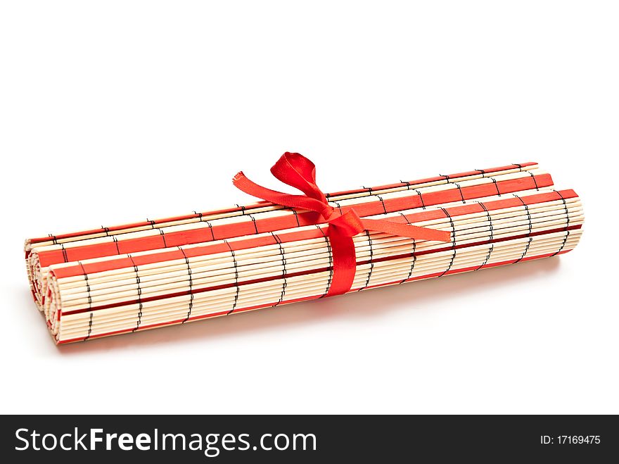 Rolled red bamboo mat. Isolated on white background. Rolled red bamboo mat. Isolated on white background