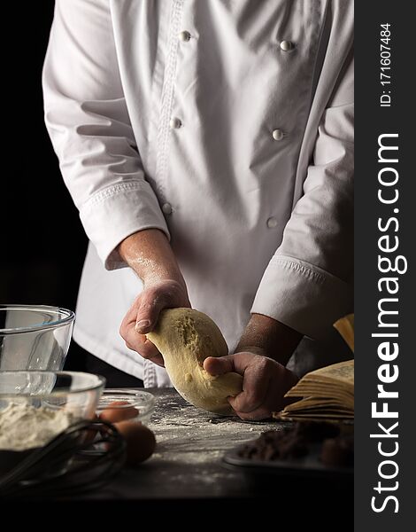 Chef makes the dough. Making dough by male hands at bakery. Cropped shot of male cooking dough for ravioli, pasta. Male chef. Close up view. Space for text