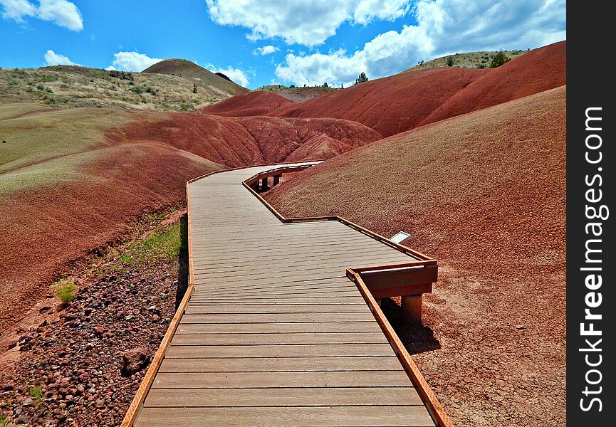 Boardwalk by a volcanic rock formation at the Painted Hills - John Day Fossil Beds National Monument - near Mitchell, OR. Boardwalk by a volcanic rock formation at the Painted Hills - John Day Fossil Beds National Monument - near Mitchell, OR