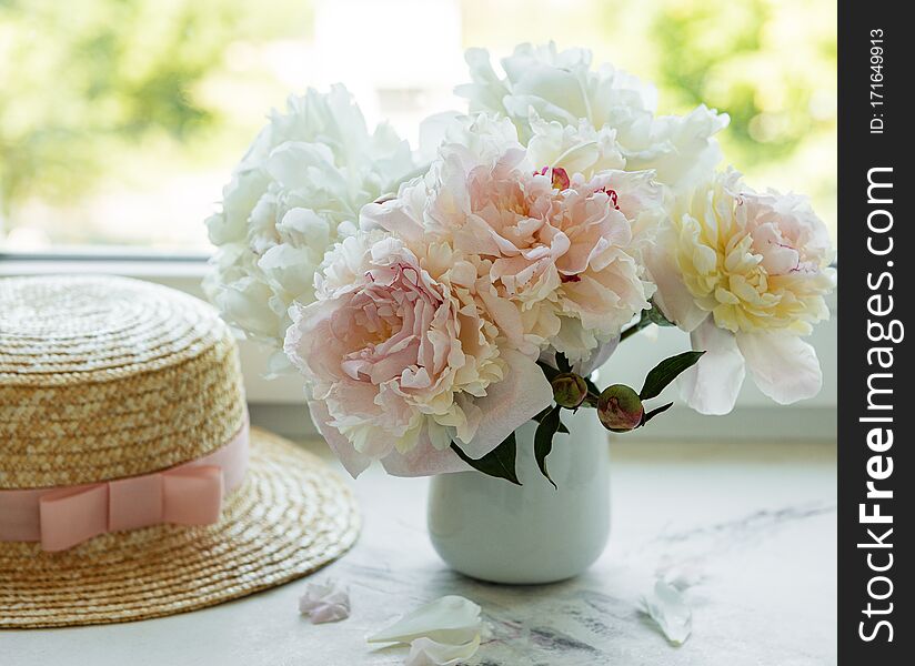 Straw hat and peonies