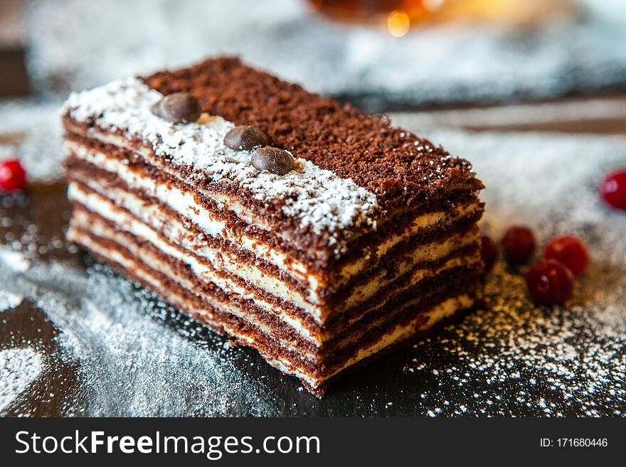 Portion of layered creamy fruit cake with in close up view. slice of tasty homemade chocolate cake on table.