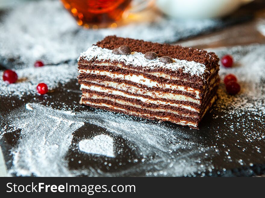 Portion of layered creamy fruit cake with in close up view. slice of tasty homemade chocolate cake on table.