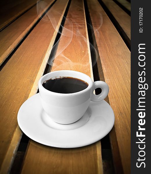 White ceramic of coffee on wood line table