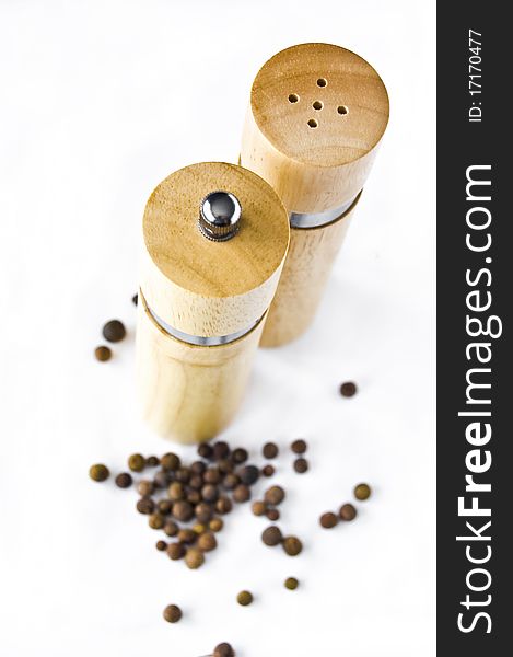 Pepper mill and grain of the allspice on white background. Pepper mill and grain of the allspice on white background