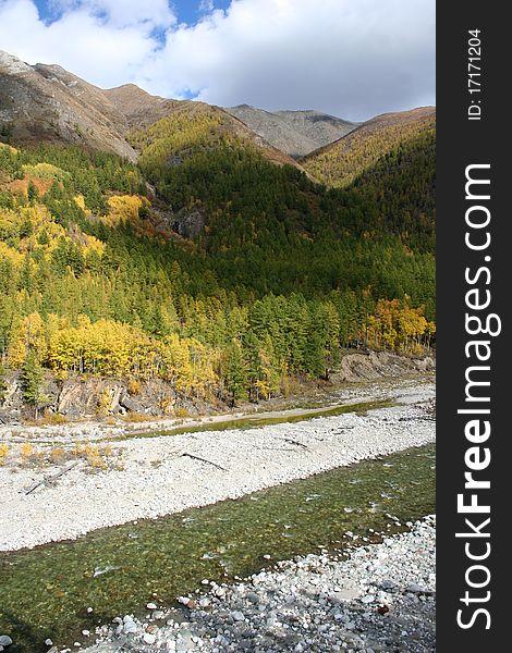 River at the foot of the autumn mountains