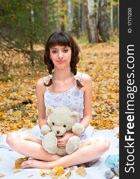 Girl with a teddy bear on the nature