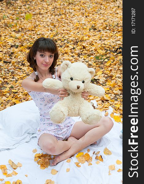 Girl with a teddy bear on the nature