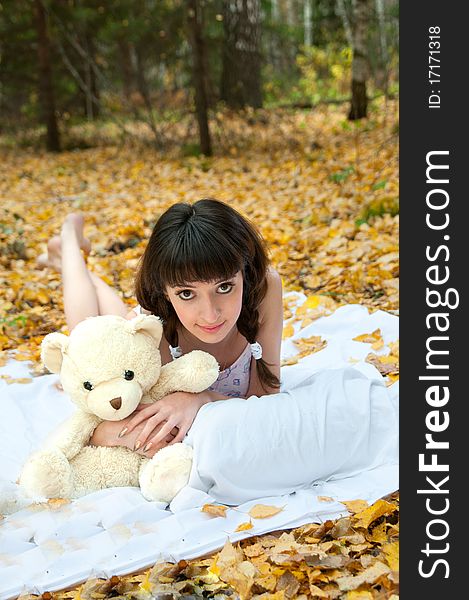 Girl with a teddy bear on the nature