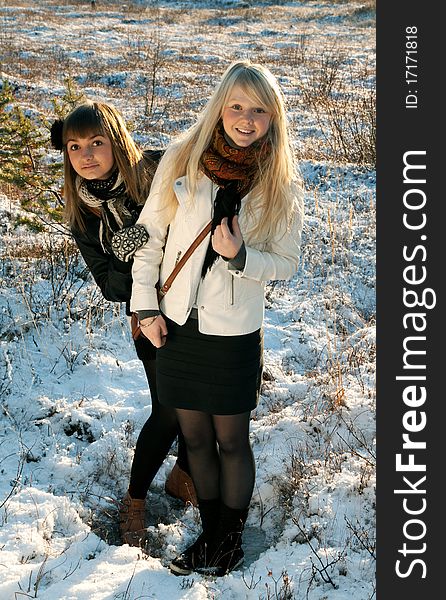 Two young beautiful girls on snow landscape