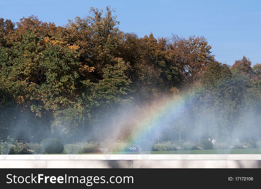 Rainbow Fountain in the background of green trees