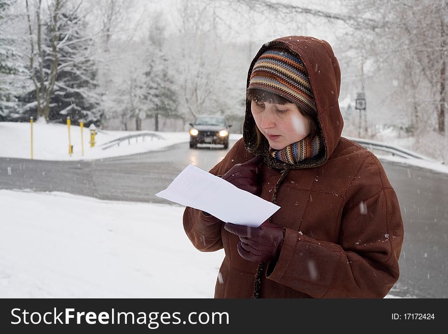 Woman reads a map under snow. Woman reads a map under snow