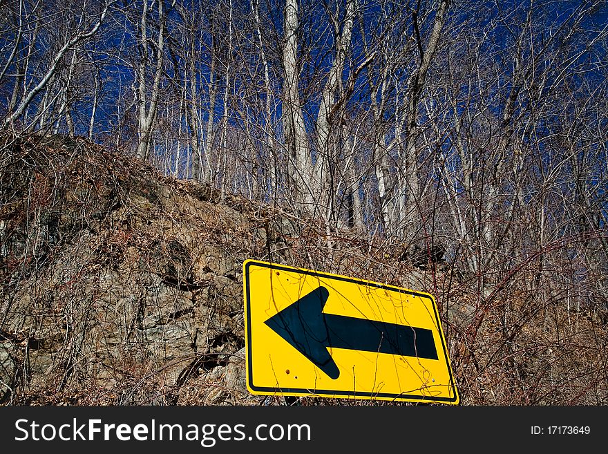 Yellow road sign and trees