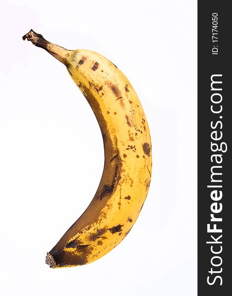 Banana with brown spots isolated over white background