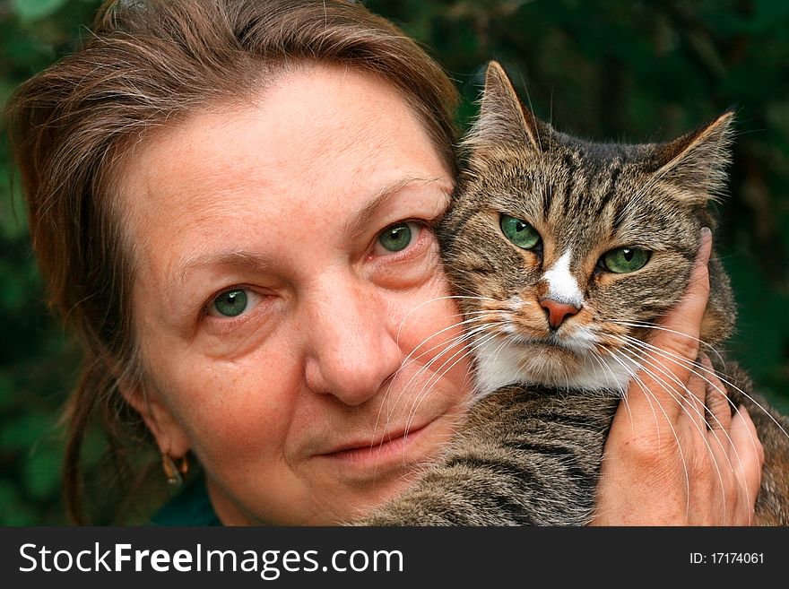 Portrait of a woman and a cat with green eyes.