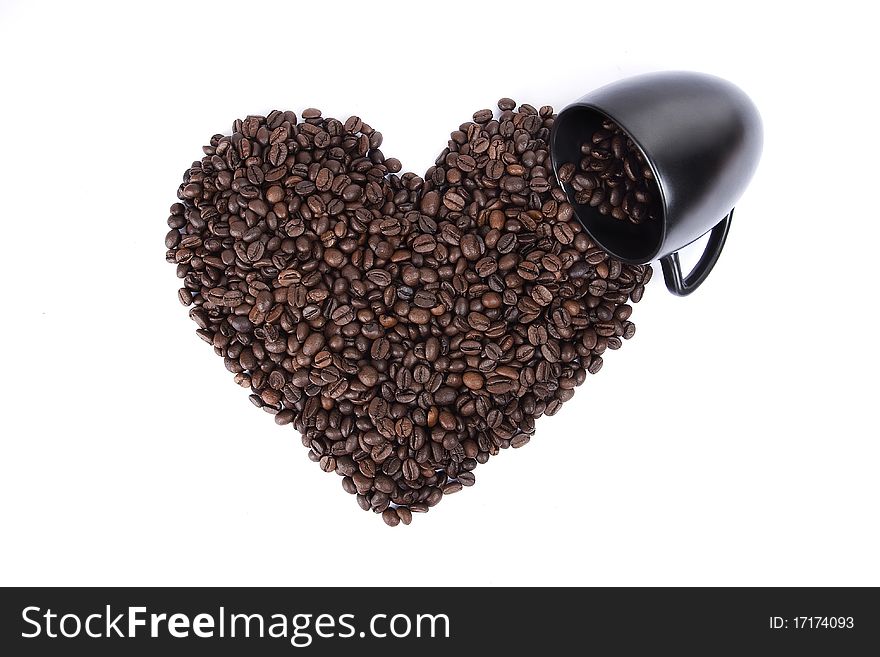 Heart shape made from coffee grains and a black cup. Heart shape made from coffee grains and a black cup