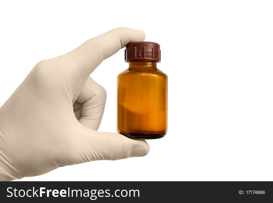 The hand in a glove on the isolated background holds a medicine