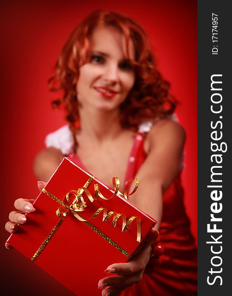 Funny redhead woman with bright red present. Funny redhead woman with bright red present
