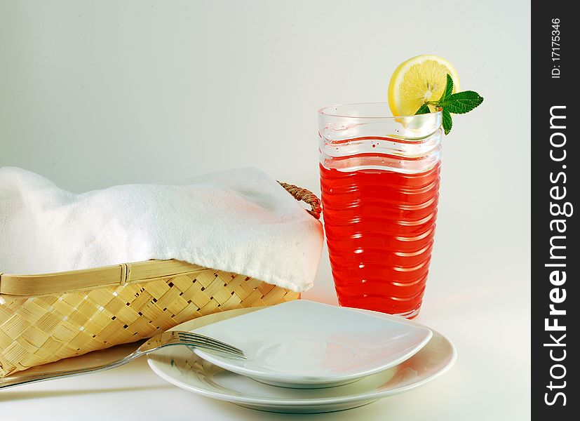 Cherry juice in a glass with a lemon on a white background. Cherry juice in a glass with a lemon on a white background