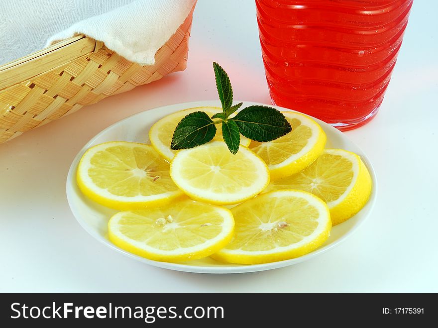 Cherry juice in a glass with a lemon on a white background. Cherry juice in a glass with a lemon on a white background