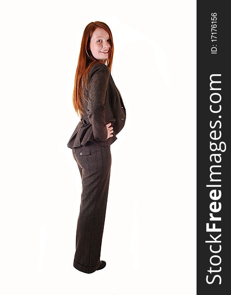 A business woman in a brown suit standing in profile in the studio,
with her long red hair for white background. A business woman in a brown suit standing in profile in the studio,
with her long red hair for white background.