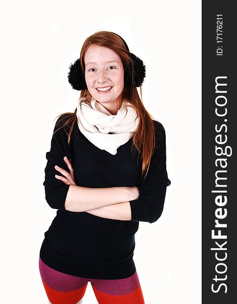 The portrait of a young woman with long red hair and ear cups and white scarf and and black sweater smiling into the camera, over white. The portrait of a young woman with long red hair and ear cups and white scarf and and black sweater smiling into the camera, over white.