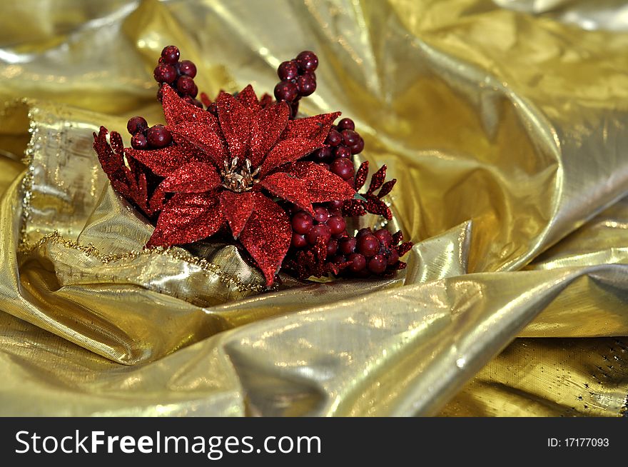 Abstract background of brilliant golden silk cloth with red christmas flower. Abstract background of brilliant golden silk cloth with red christmas flower