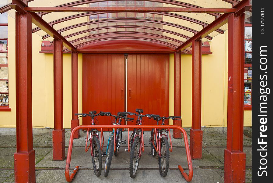 A row of commuter bikes parked against a vibrant backdrop. A row of commuter bikes parked against a vibrant backdrop.