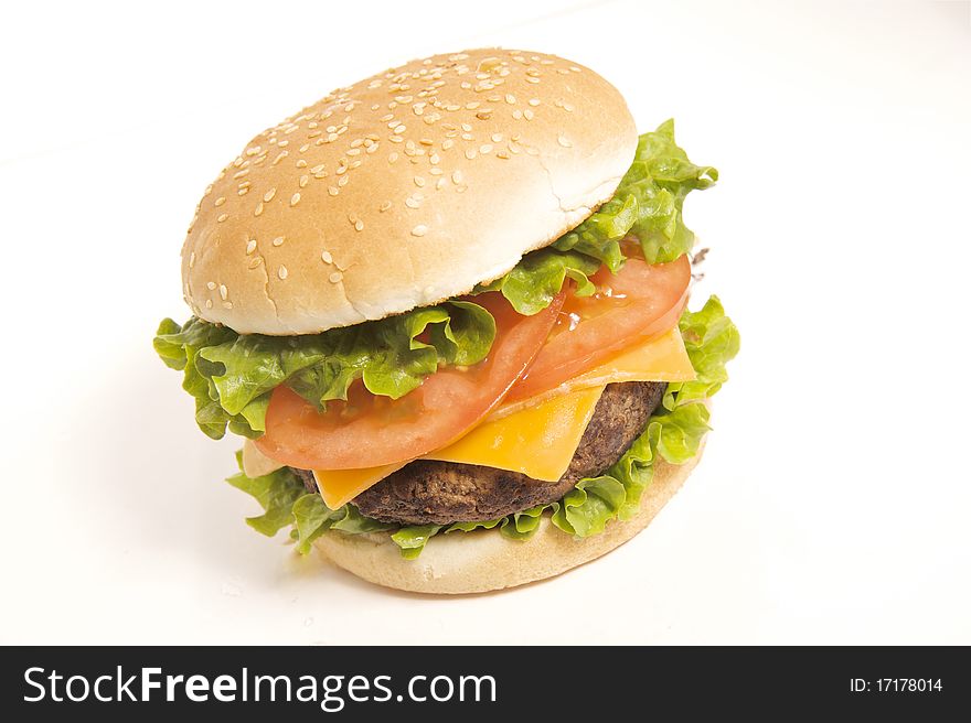 Delicious juicy fresh grilled cheeseburger on a sesame bun. Shot in studio, isolated on white background.